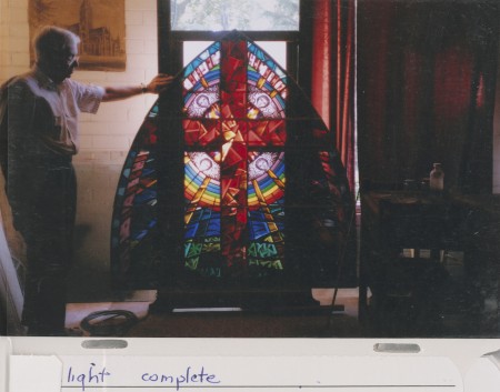 Philip Handel holding a stained glass window from photo album by Philip and Elizabeth Handel